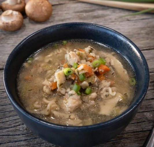 A bowl of Chicken Noodle Soup with visible chunks of chicken, noodles, and vegetables like carrots and onions.